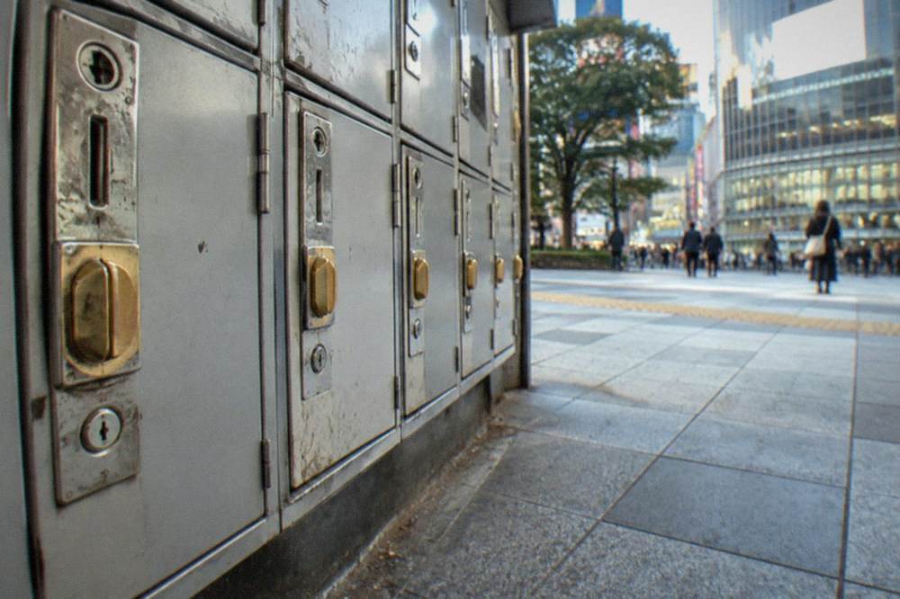 Locker key slots and coin slots on a bank of grey lockers