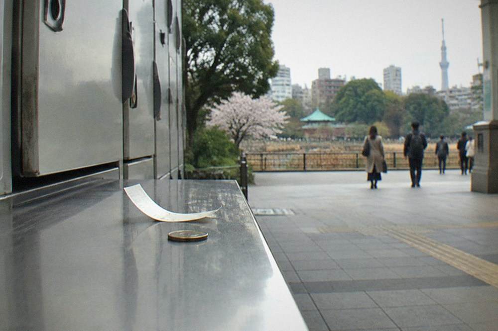 a paper locker ticket with a printed code resting on a station bench