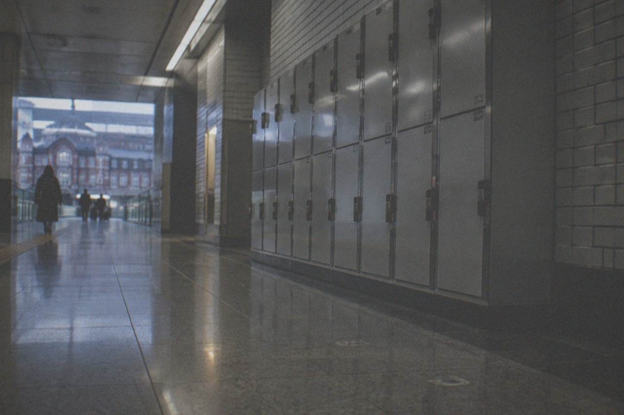 a row of grey coin lockers along a quiet Tokyo station corridor