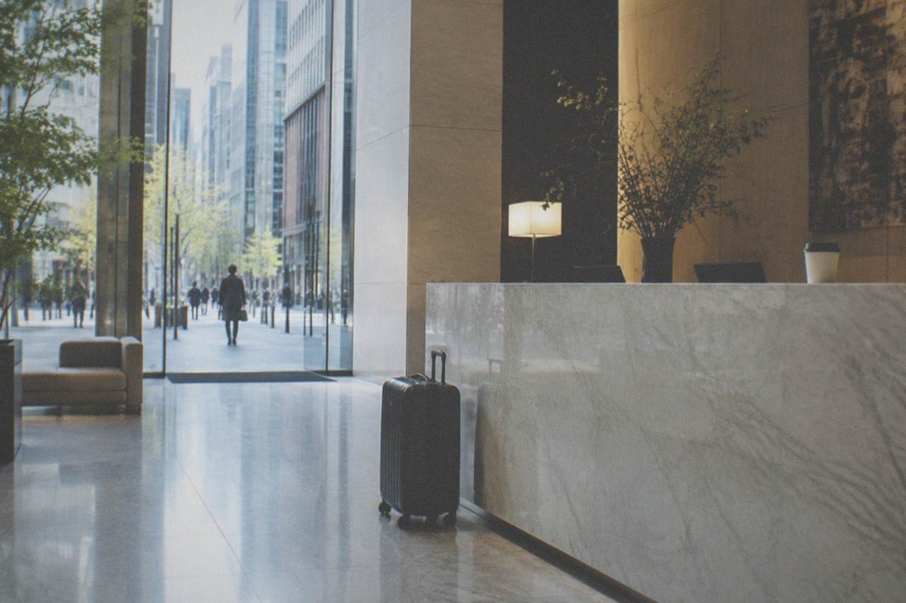 An empty hotel front desk in Tokyo with a closed suitcase standing beside the counter