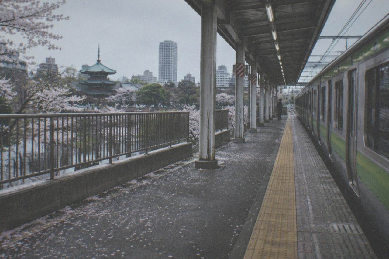 A quiet railway platform in Tokyo with a train waiting beside the tracks