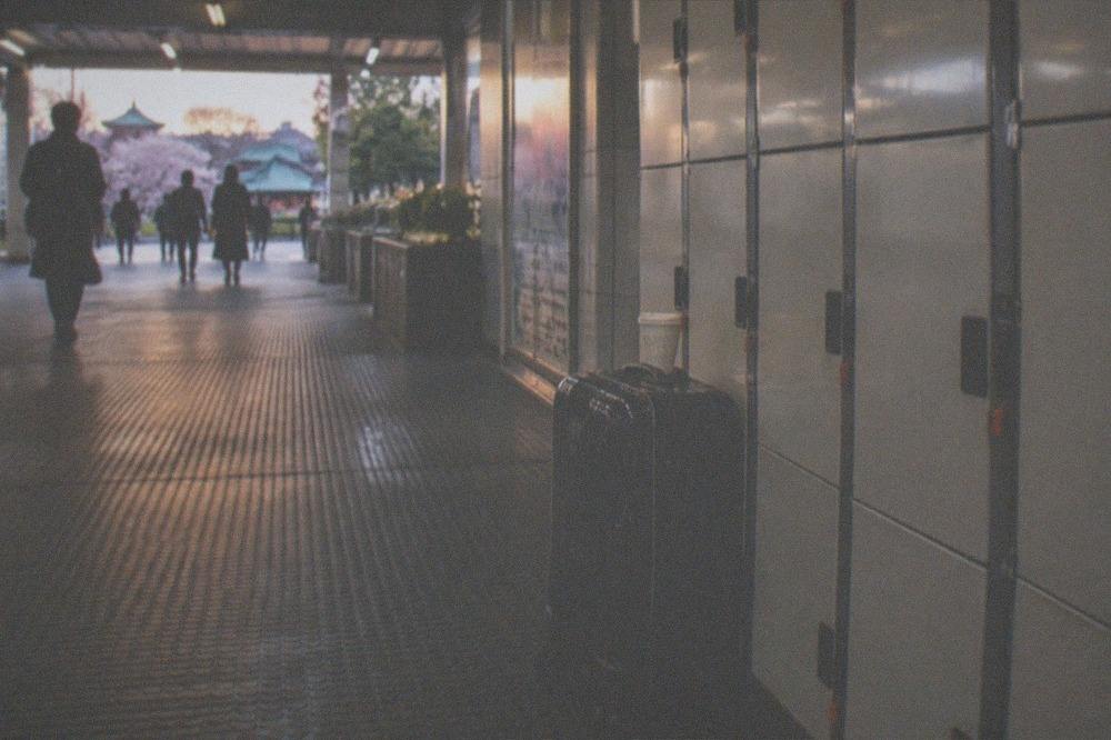 A single suitcase parked beside a bank of station lockers