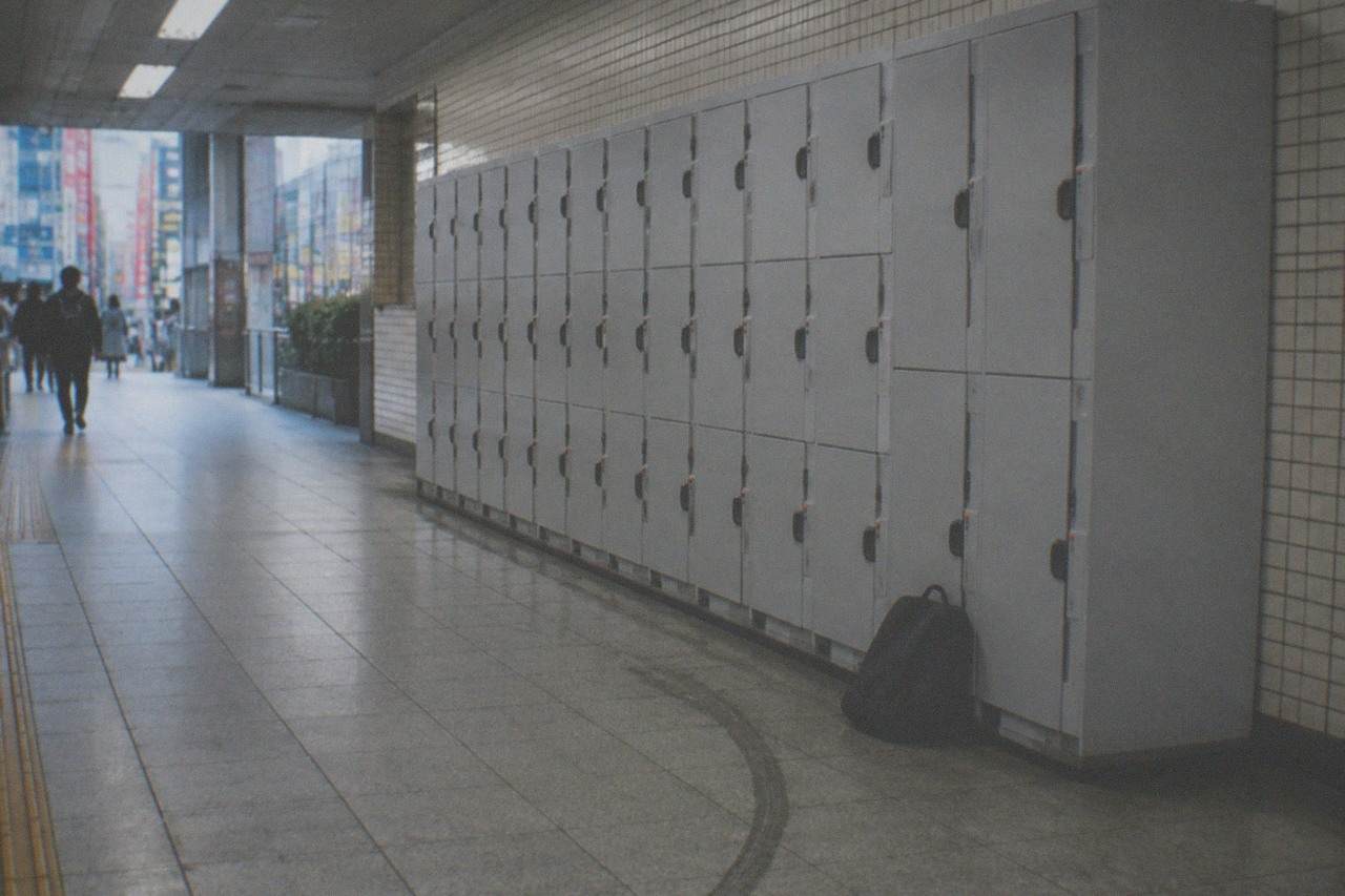 Rows of grey coin lockers along a quiet Tokyo subway station corridor