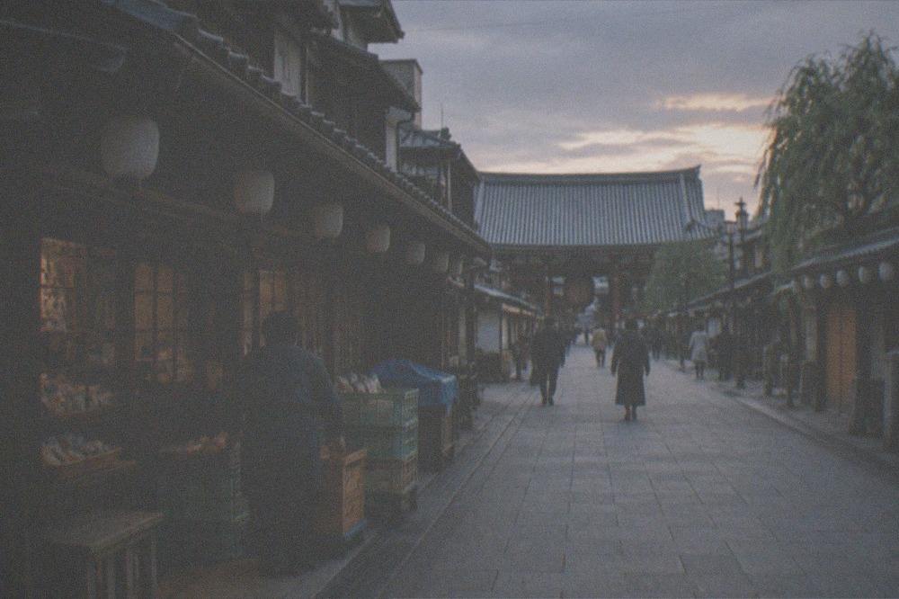 Narrow shopping street in Asakusa with a temple gate in the distance