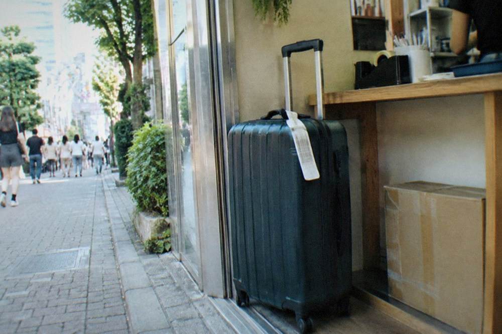 A staffed shop counter in Tokyo with a suitcase waiting to be tagged for storage