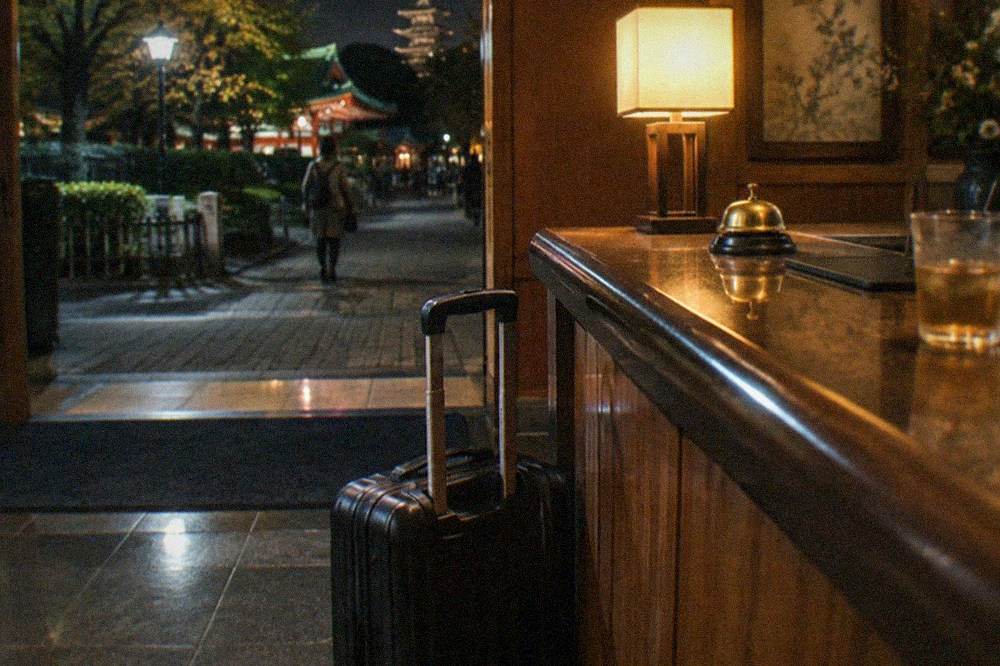 A hotel front desk counter with a suitcase parked beside it