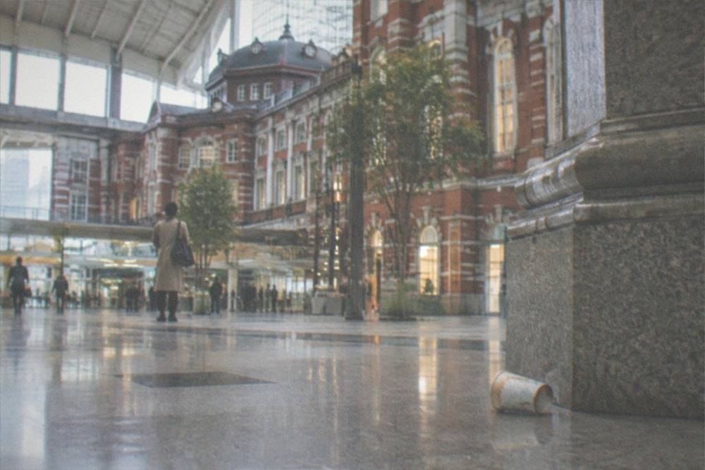 A signage board in Tokyo Station showing baggage room directions with Japanese text