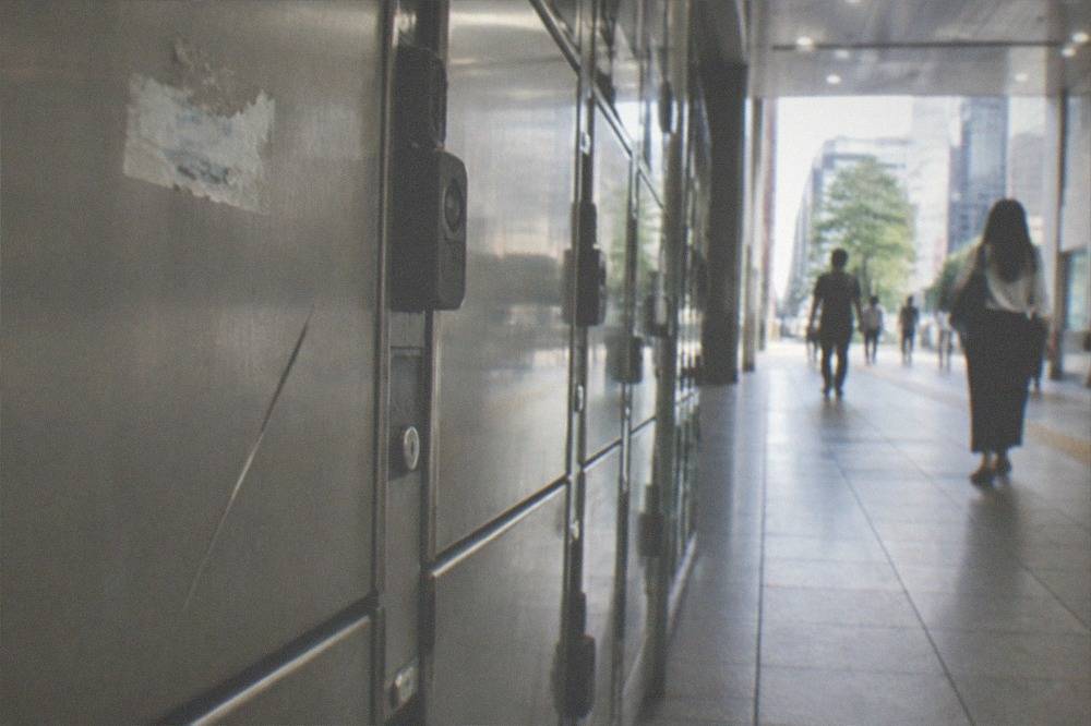 A close view of coin locker doors with numbered panels in a Tokyo station passage