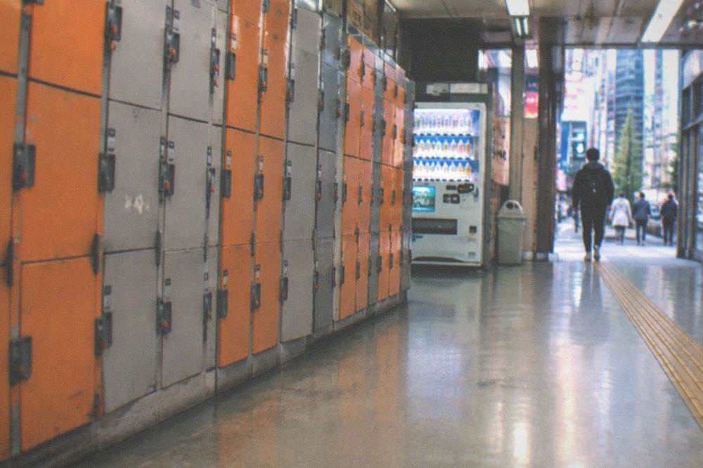 Rows of orange and grey coin lockers along a Tokyo station corridor