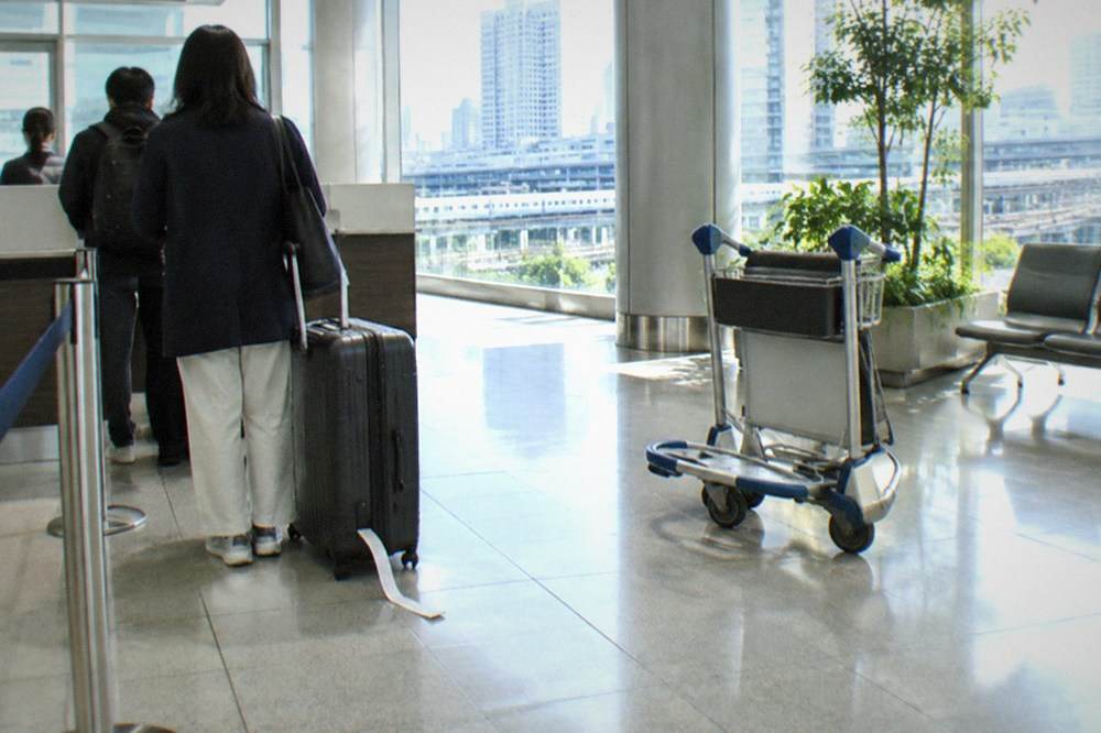 A departure lobby counter with a suitcase queued for airport delivery