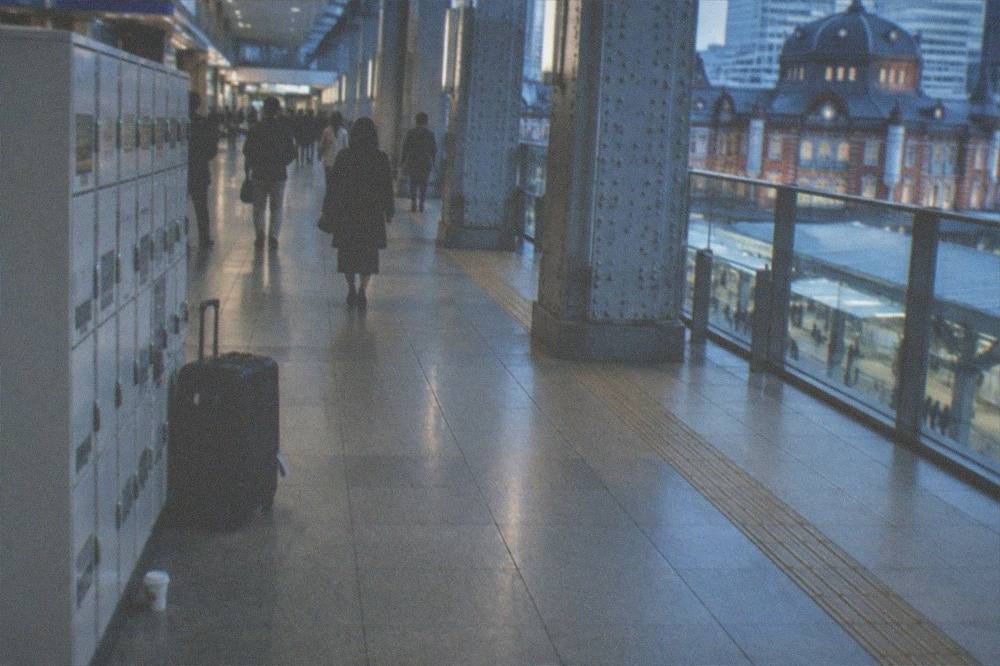 A wide suitcase beside a coin locker bank in a station corridor