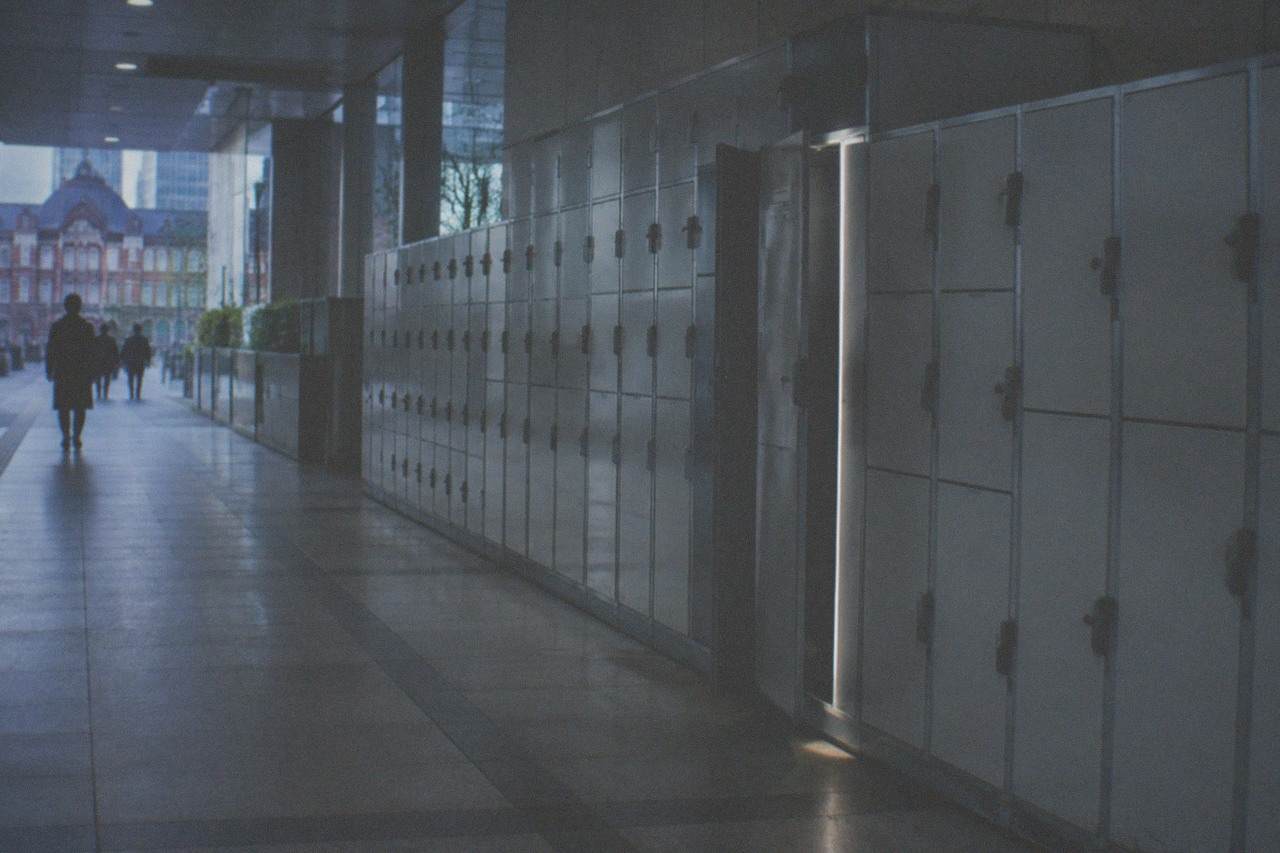 Rows of coin lockers in varying sizes along a Tokyo station corridor