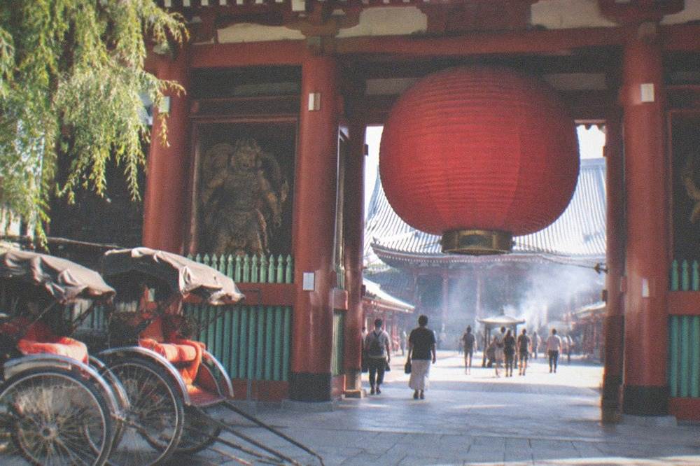 The main entrance gate of Senso-ji temple in Asakusa with visitors and rickshaws