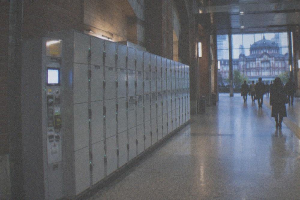 Rows of grey coin lockers along a station corridor with a payment panel visible